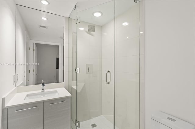 bathroom with vanity, an enclosed shower, and toilet