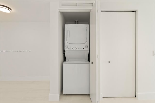 clothes washing area featuring stacked washer / drying machine