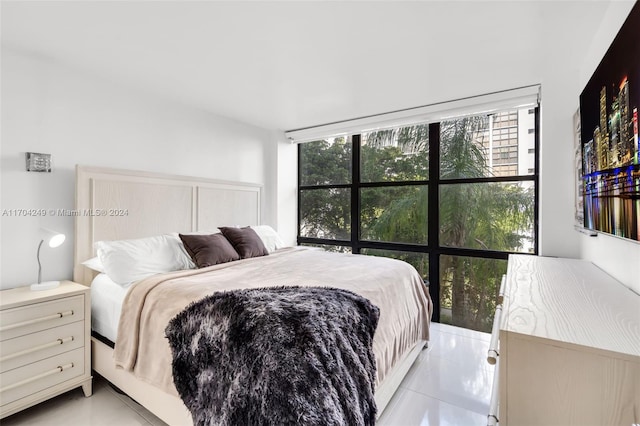 bedroom with expansive windows and light tile patterned flooring