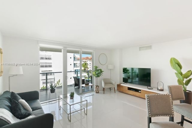 living room featuring expansive windows and light tile patterned flooring