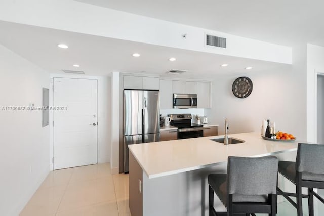 kitchen with white cabinetry, kitchen peninsula, sink, and appliances with stainless steel finishes