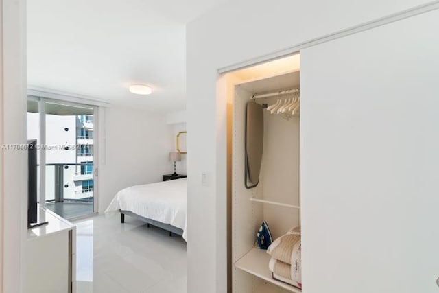 bedroom featuring access to exterior, a closet, and a wall of windows