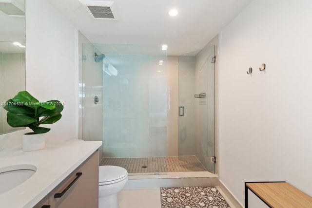 bathroom featuring tile patterned flooring, vanity, toilet, and an enclosed shower