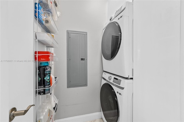 laundry room with electric panel and stacked washer and dryer