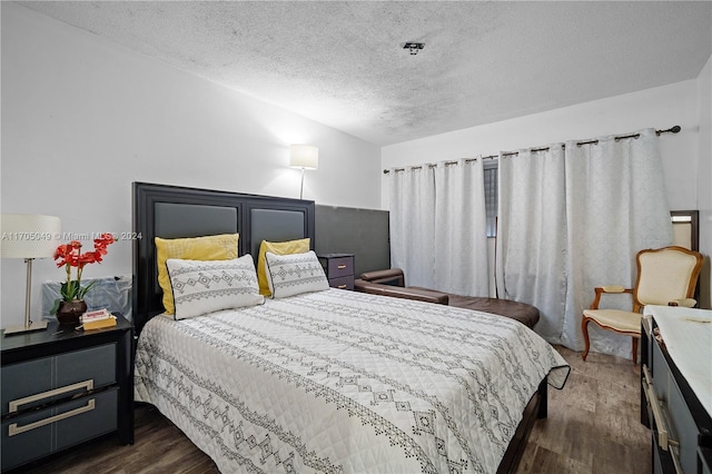 bedroom featuring dark hardwood / wood-style floors and a textured ceiling