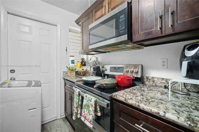 kitchen featuring dark brown cabinets, light wood-type flooring, light stone countertops, and appliances with stainless steel finishes