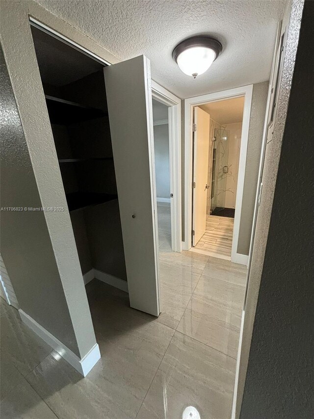 hallway with a textured ceiling