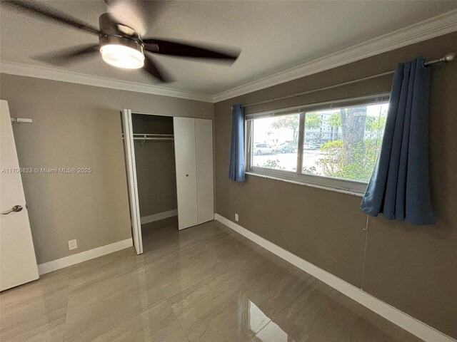 unfurnished bedroom featuring ceiling fan, a closet, and ornamental molding