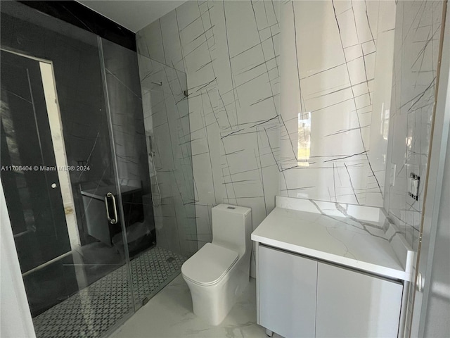 bathroom featuring vanity, toilet, a shower with door, and tile walls