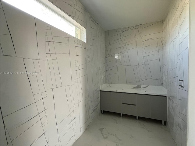 bathroom with vanity and tile walls