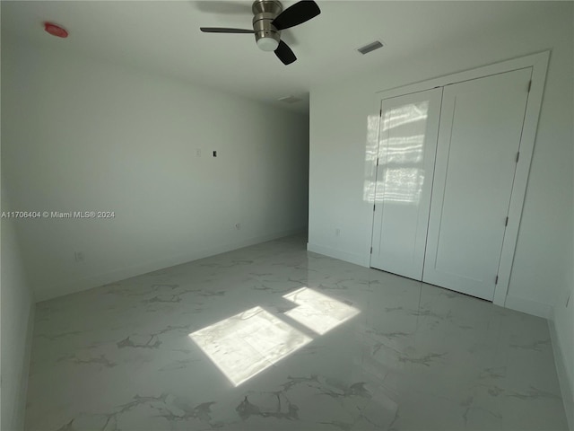 unfurnished bedroom featuring ceiling fan and a closet