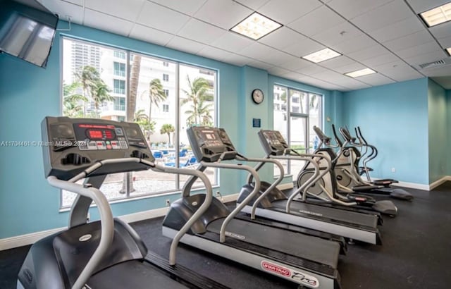 workout area featuring plenty of natural light and a drop ceiling