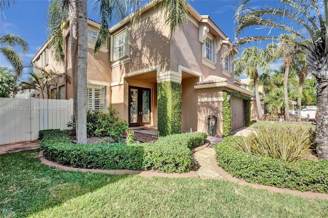 view of front of home with a garage and french doors