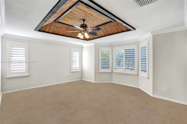 carpeted spare room featuring a textured ceiling, ceiling fan, and ornamental molding