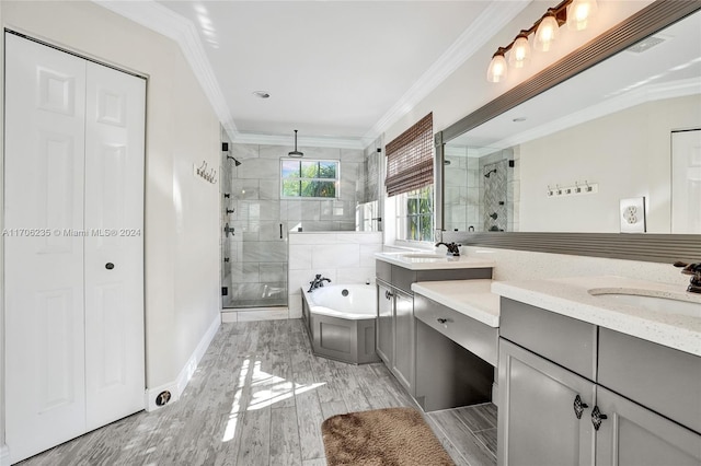 bathroom featuring hardwood / wood-style floors, vanity, separate shower and tub, and ornamental molding