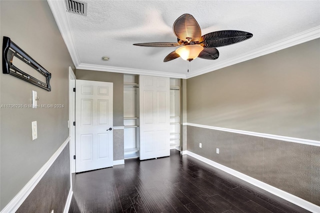 unfurnished bedroom featuring ceiling fan, ornamental molding, a textured ceiling, dark hardwood / wood-style flooring, and a closet