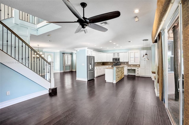 kitchen with white cabinetry, a center island, hanging light fixtures, dark hardwood / wood-style flooring, and appliances with stainless steel finishes