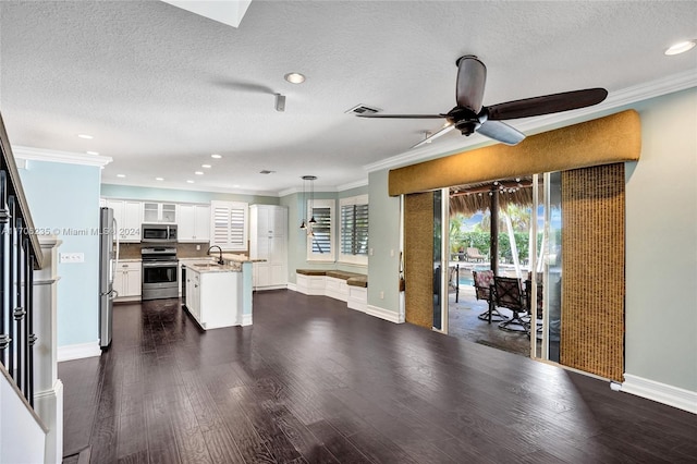 kitchen featuring sink, a center island, dark hardwood / wood-style flooring, white cabinets, and appliances with stainless steel finishes