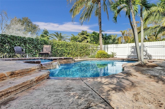 view of pool with pool water feature, a patio, and a hot tub