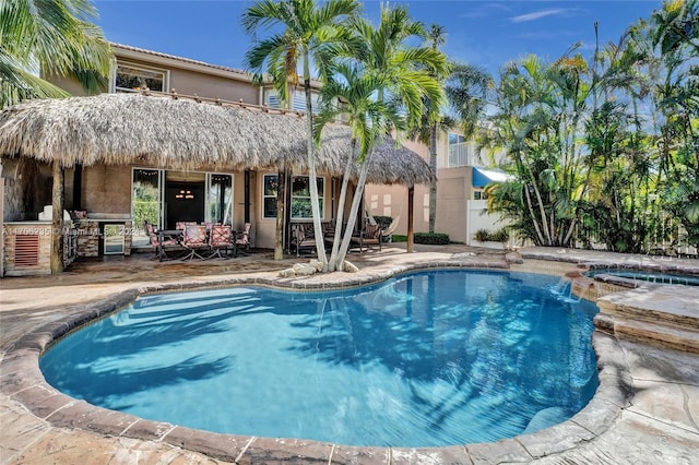 view of pool featuring a patio area, an in ground hot tub, and area for grilling