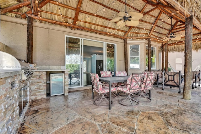 view of patio with an outdoor kitchen, area for grilling, ceiling fan, a gazebo, and wine cooler