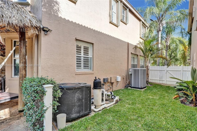 exterior space featuring central AC unit and a yard