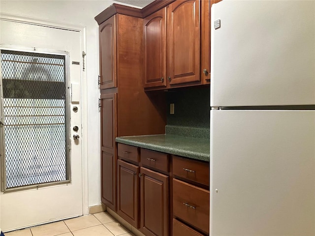 kitchen with light tile patterned floors and white refrigerator