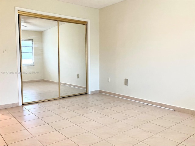 unfurnished bedroom with a closet and light tile patterned flooring