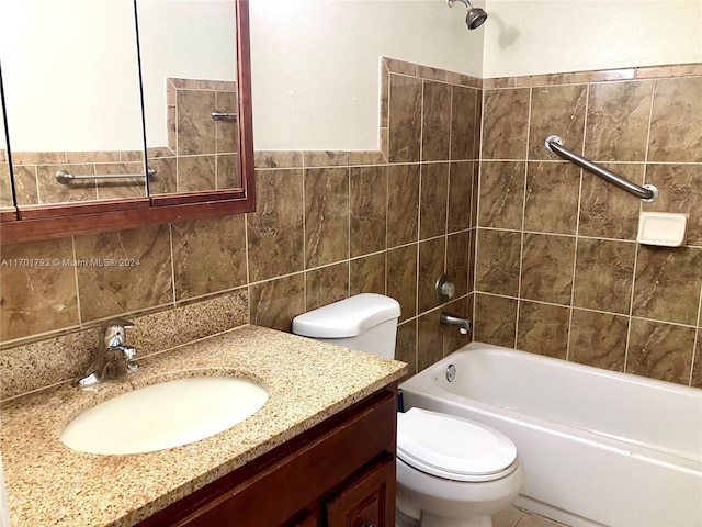 full bathroom with vanity, toilet, tiled shower / bath, and tile walls