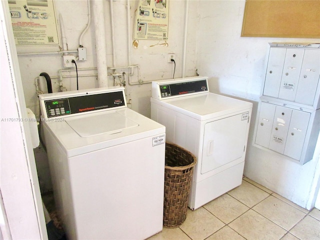 washroom with washing machine and dryer and light tile patterned floors