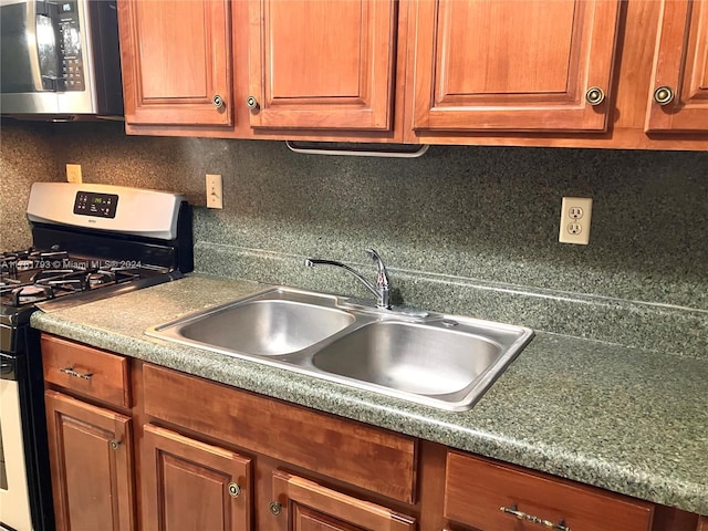 kitchen featuring backsplash, sink, and white gas range oven