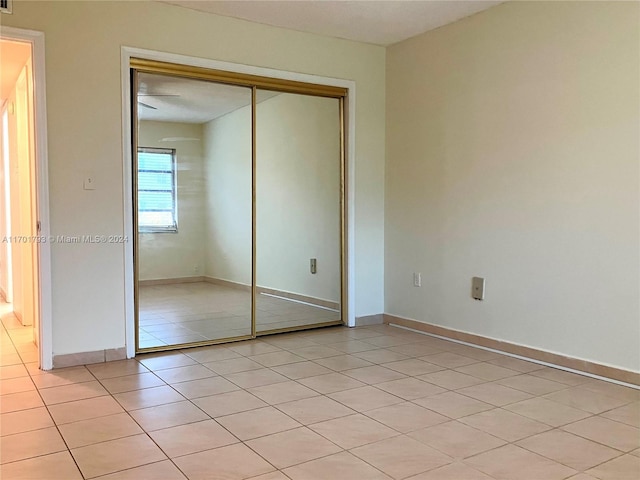 unfurnished bedroom featuring light tile patterned flooring and a closet