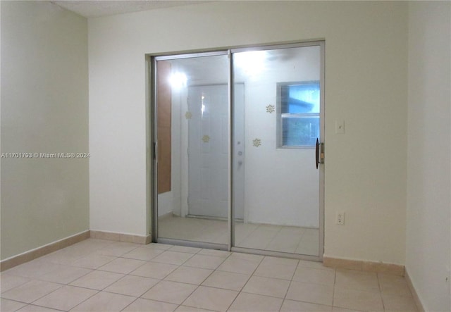 unfurnished bedroom featuring light tile patterned floors and a closet