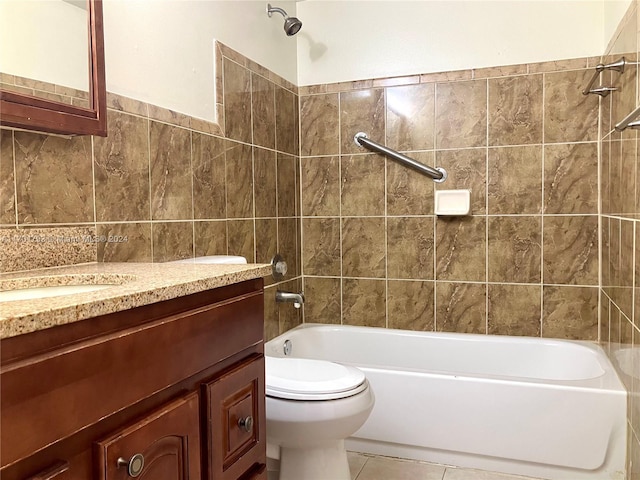 full bathroom featuring tile patterned flooring, toilet, vanity, tile walls, and tiled shower / bath