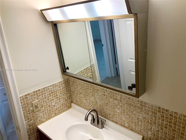 bathroom with vanity and tile walls