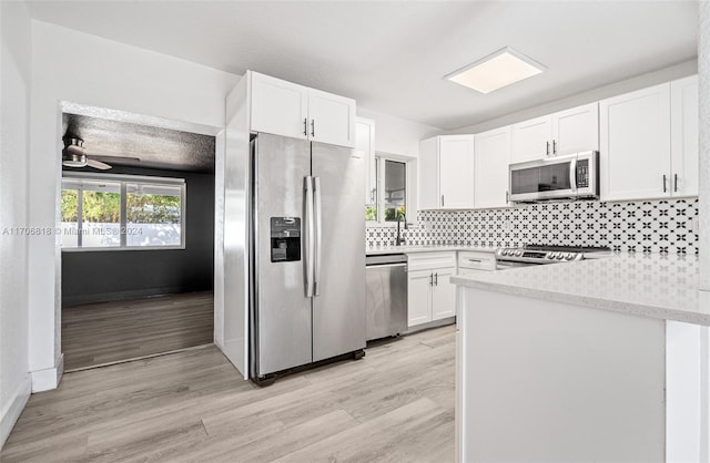 kitchen featuring sink, light hardwood / wood-style flooring, ceiling fan, appliances with stainless steel finishes, and white cabinetry