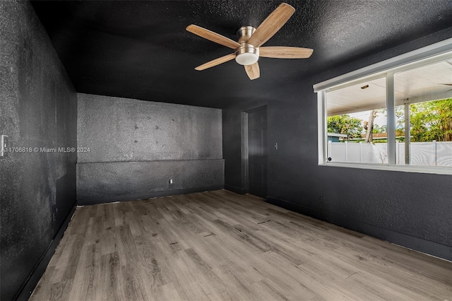 spare room with ceiling fan, a textured ceiling, and light hardwood / wood-style flooring