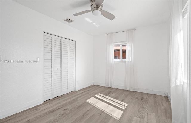 unfurnished bedroom featuring ceiling fan, light hardwood / wood-style flooring, and a closet