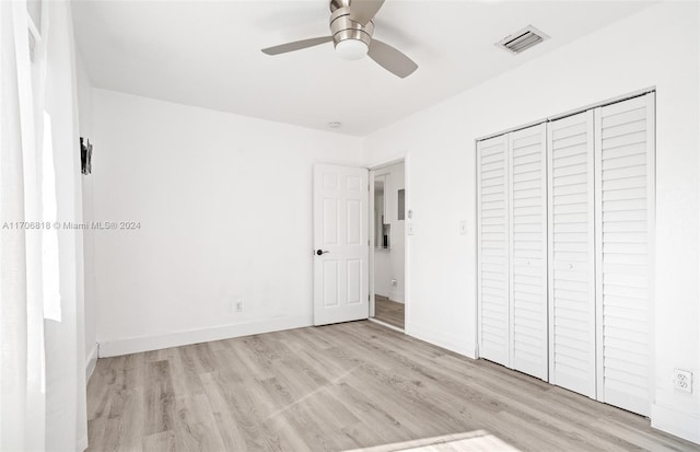 unfurnished bedroom featuring ceiling fan, a closet, and light hardwood / wood-style flooring