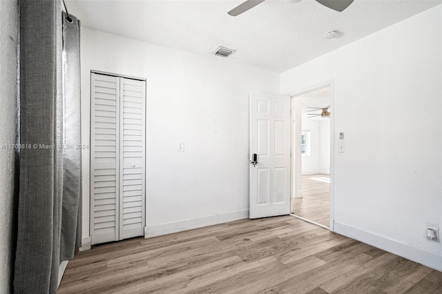 unfurnished bedroom featuring light wood-type flooring, a closet, and ceiling fan