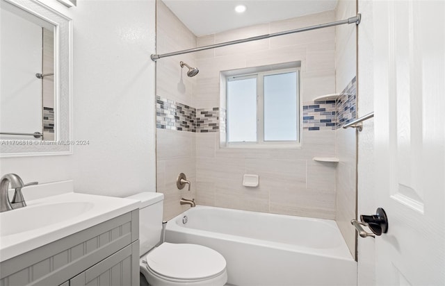 full bathroom featuring vanity, tiled shower / bath combo, and toilet