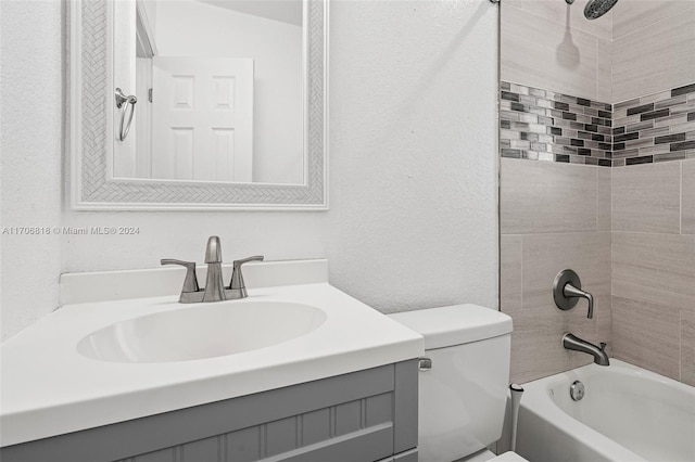 full bathroom with toilet, vanity, and tiled shower / bath