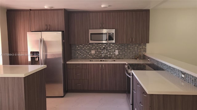 kitchen with decorative backsplash, dark brown cabinets, sink, and appliances with stainless steel finishes