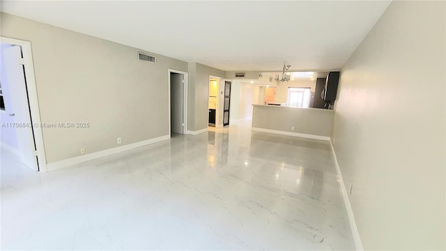 unfurnished living room featuring an inviting chandelier