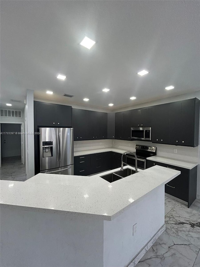 kitchen with sink, a kitchen island with sink, and appliances with stainless steel finishes