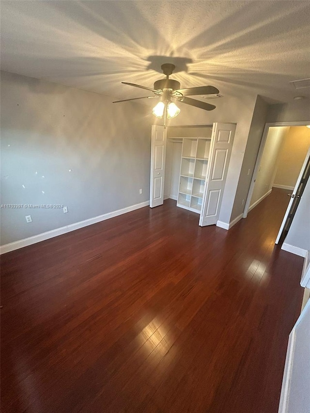 spare room featuring a textured ceiling, ceiling fan, and dark wood-type flooring