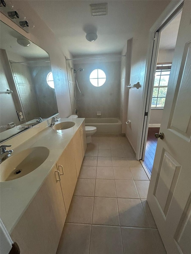 full bathroom with toilet, vanity, tile patterned floors, and tiled shower / bath