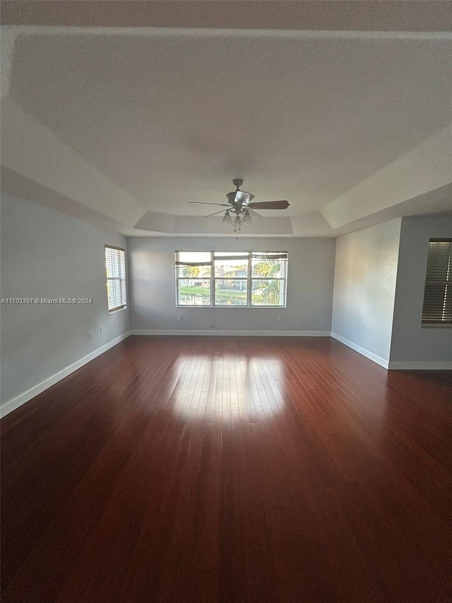 spare room featuring ceiling fan and dark wood-type flooring