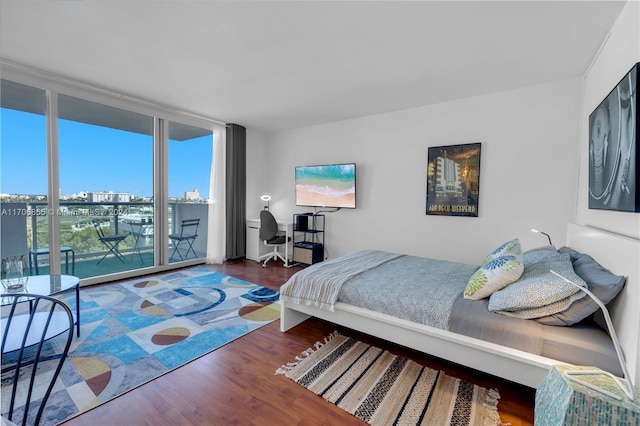 bedroom featuring access to exterior, expansive windows, and dark hardwood / wood-style floors