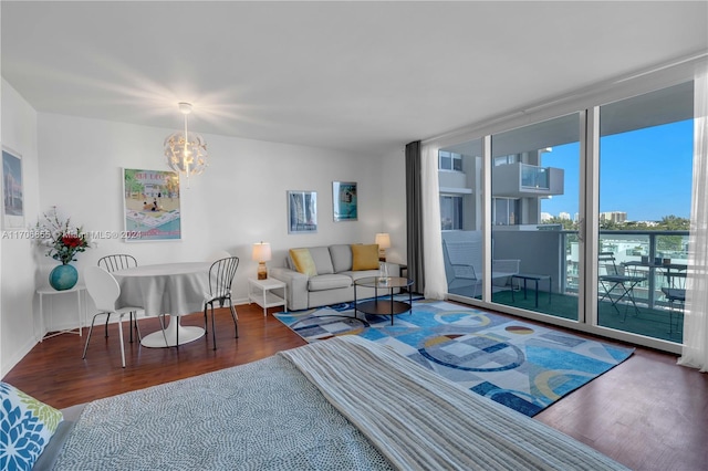 living room featuring hardwood / wood-style floors, expansive windows, and an inviting chandelier